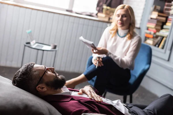 Bebaarde zakenman liggend op de bank terwijl het hebben van psychologische therapie — Stockfoto