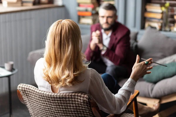 Therapist wearing white blouse giving personal assistance to businessman — Stock Photo, Image