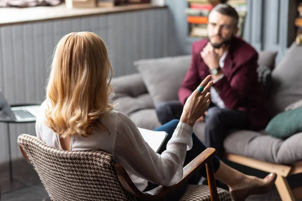 Blonde-haired therapeut draagt blauwe ring praten met bebaarde man — Stockfoto