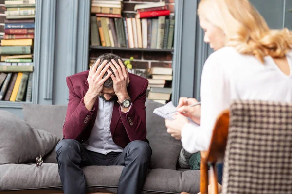 Hombre tocándose la cabeza mientras se siente aterrorizado teniendo muchos problemas — Foto de Stock