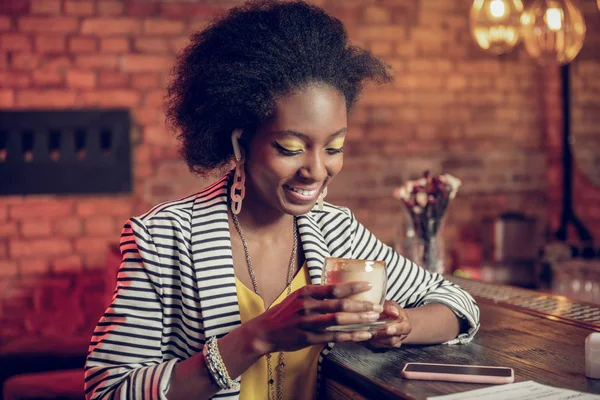 Retrato de la hechizante mujer afroamericana sosteniendo una taza de café —  Fotos de Stock