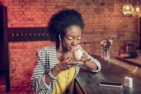 Retrato de cerca de una mujer afroamericana oliendo el aroma del café en la cafetería — Foto de Stock