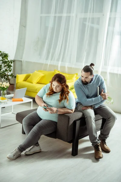 Concentrated overweight female person using her smartphone — Stock Photo, Image