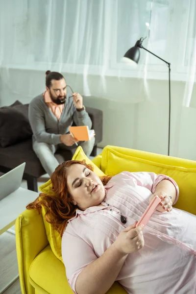 Attente langharige vrouwelijke persoon staren naar haar gadget — Stockfoto