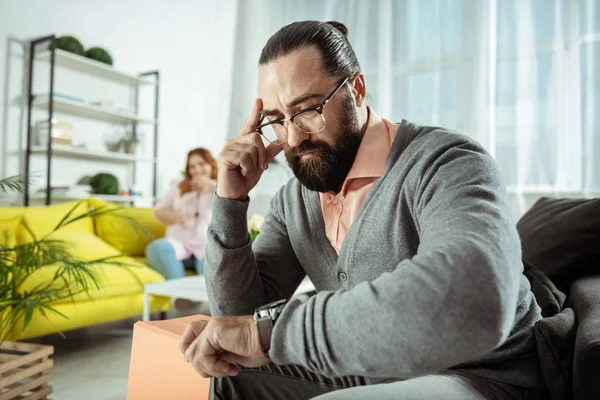 Geconcentreerde jonge psycholoog tijd op horloges controleren — Stockfoto