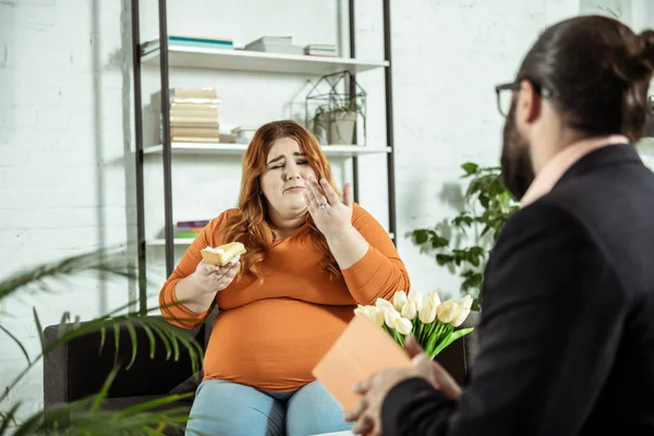 Terapeuta profissional entrevistando seu jovem cliente gordo — Fotografia de Stock