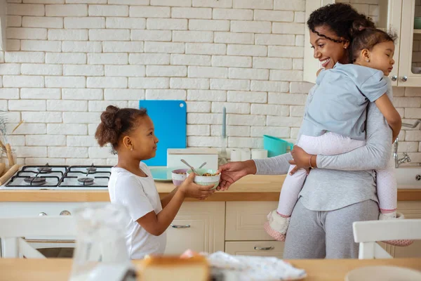 Gioioso bruna donna holding suo sleepy figlia — Foto Stock