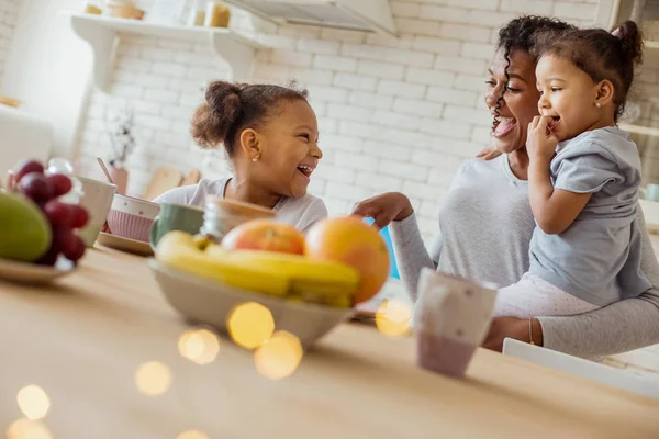 Deliziosa donna dai capelli ricci che trascorre la mattina con i suoi figli — Foto Stock