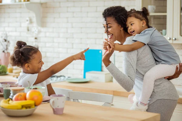 Positiv glad ung kvinna leker med döttrar — Stockfoto