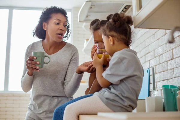 Attenta donna dai capelli ricci che sostiene il suo bambino — Foto Stock