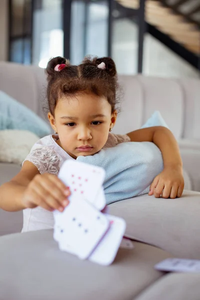 Concentrato bambina prendendo pallido di carte — Foto Stock