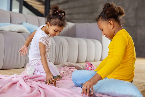 Niedliche Kinder sitzen auf rosa Decke im Wohnzimmer — Stockfoto