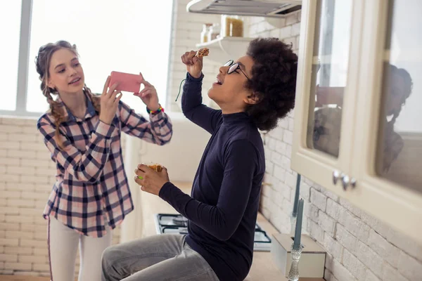 Fröhliche Kinder, die zusammen mit Essen in der Küche spielen — Stockfoto