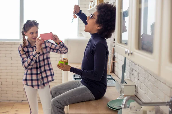 Lindo niño de pelo largo usando su teléfono durante el juego —  Fotos de Stock