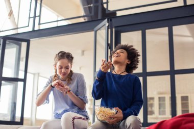 Zevk ile patlamış mısır yemek çekici uzun saçlı kız