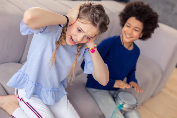 Unhappy longhaired girl putting hands on her ears — Stock Photo, Image