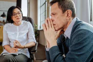 Mavi kazaklı bir kenara tartışırken bakarak kısa saçlı adam üzgün