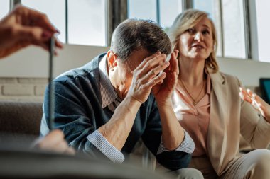 Kısa saçlı yaşlar yanakları üzerinden silinerek adam üzgün
