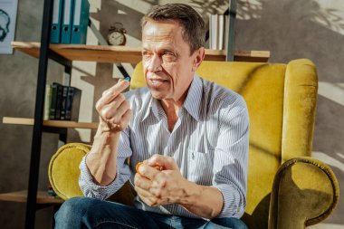 Hap alarak kahverengi gözlü hoş olmayan yaşlı adam