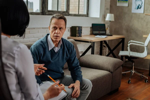 Disturbed adult guy in blue cardigan being shocked during conversion with doctor — Stock Photo, Image