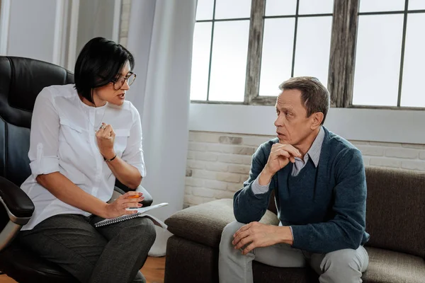 Expressive therapist with bob haircut and clear glasses having conversation — Stock Photo, Image