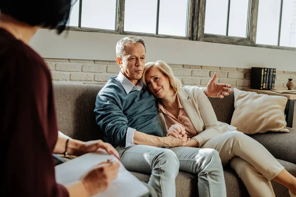 Short-haired old man supporting his crying wife while explaining problem — Stock Photo, Image
