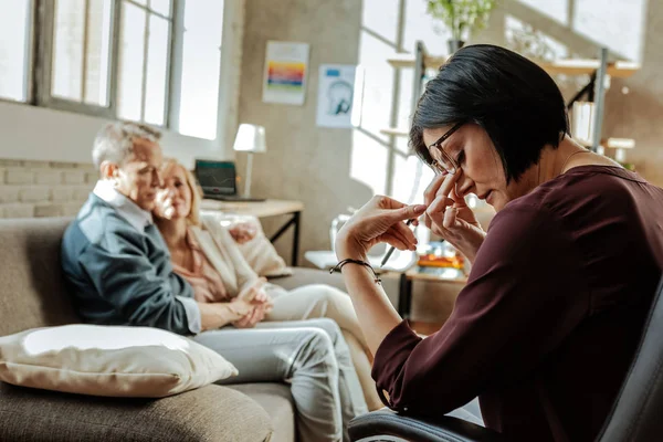 Ongelukkig dark-haired vrouw wrijven haar neus wordt moe — Stockfoto