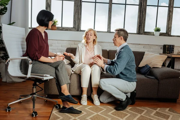 Expressive blonde woman in light costume explaining her feelings to psychotherapist — Stock Photo, Image