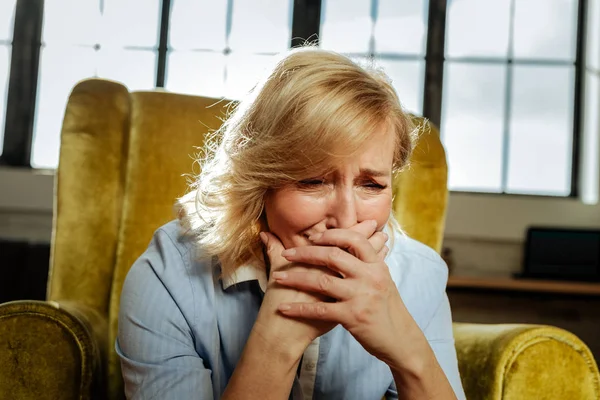Desperate short-haired middle-age woman closing half of her face — Stock Photo, Image