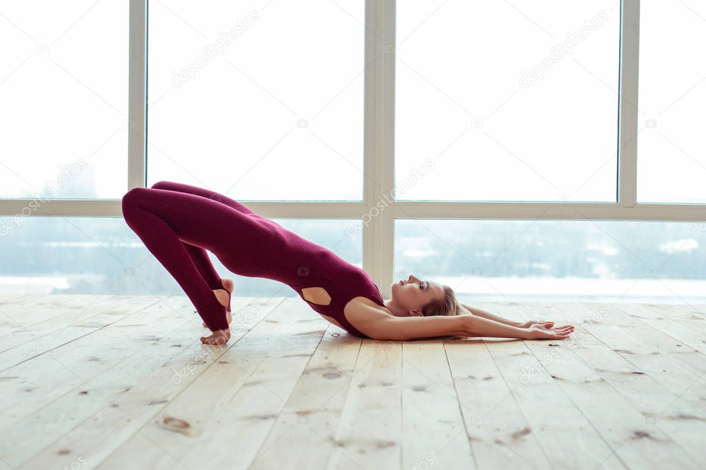 Peaceful and calm well-trained girl party-lying on wooden floor