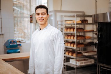 İşe gitmeden önce heyecanlı hissederken gülümseyen genç esmer baker