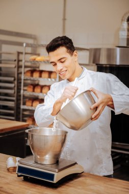 Mutfak terazisi duran ve unu ekleyerek genç baker