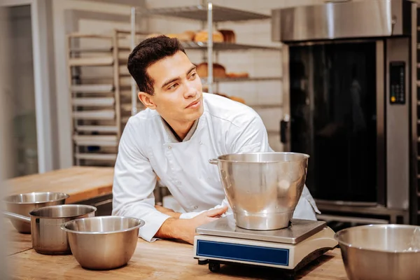 Baker bär vita uniform stående nära köksvåg — Stockfoto