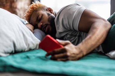 Onun akıllı telefon ekranına bakarak hoş güzel adam