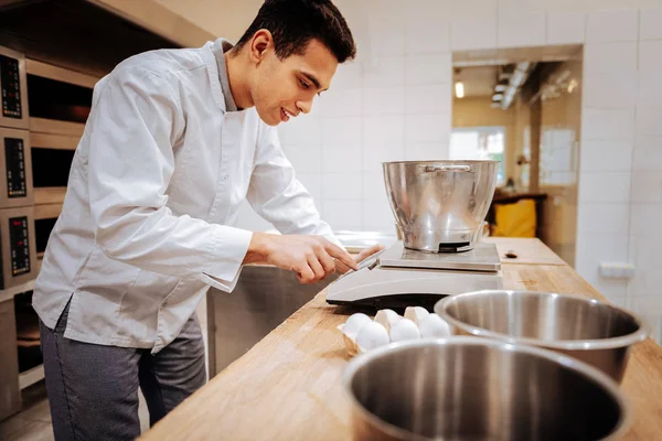 Baker visel fehér kabátot használ modern konyhai mérlegek — Stock Fotó