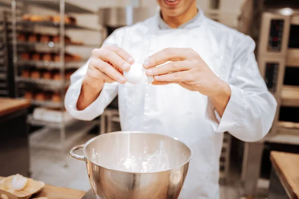 Primo piano del fornaio professionista che rompe l'uovo nella ciotola — Foto Stock