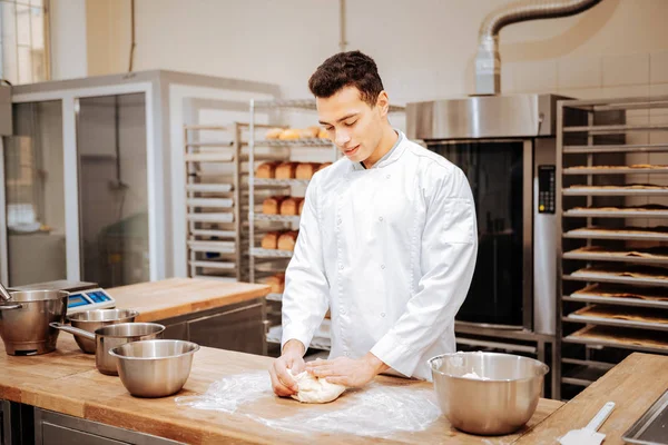 Baker uczucie zajęty podczas wyrabiania ciasta rano — Zdjęcie stockowe