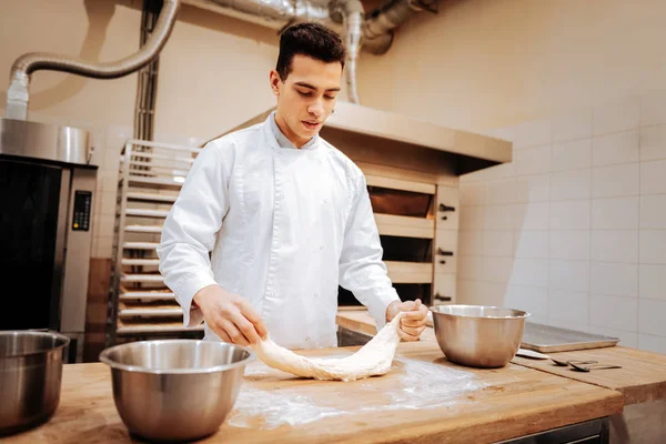 Baker vistiendo uniforme blanco sintiéndose ocupado trabajando duro — Foto de Stock