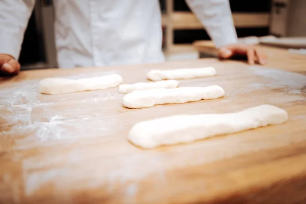Close up of tray with formed dough for future little baguettes