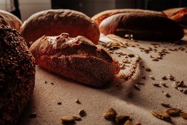 Dark rye gluten free bread lying near spikelet and seeds