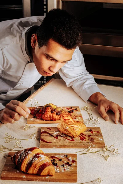 Baker decorando três sobremesas incríveis para clientes — Fotografia de Stock