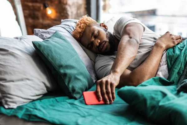Aardige slaperig man met zijn mobiele telefoon — Stockfoto