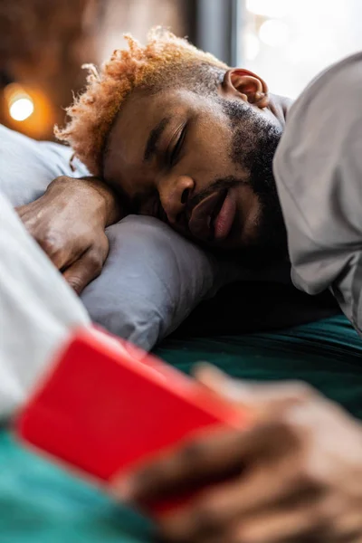 Agradable hombre afroamericano escuchando el despertador — Foto de Stock