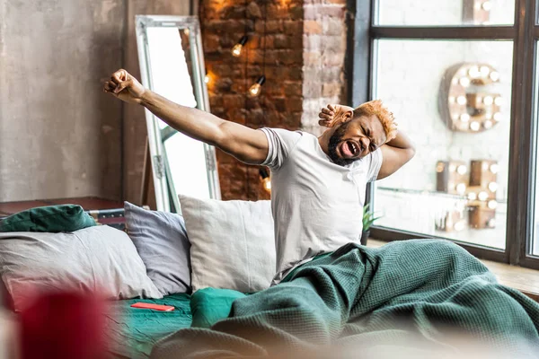 Aangename Afro-Amerikaanse man, wakker worden in zijn bed — Stockfoto