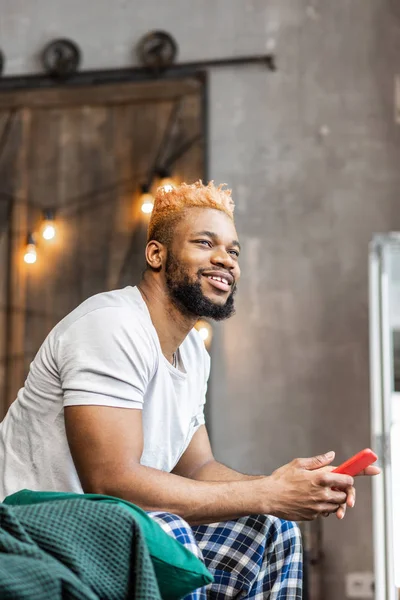 Bonito hombre bien parecido sentado con su teléfono — Foto de Stock