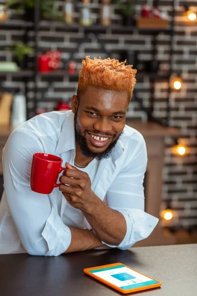 Blij vrolijke jongeman zijn koffie drinken — Stockfoto