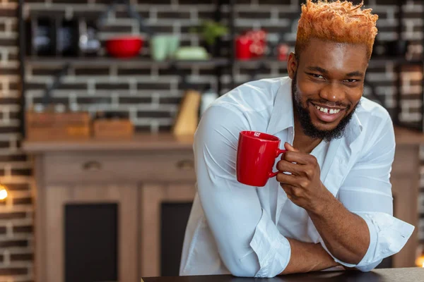 Uomo afroamericano positivo con una coppa rossa in mano — Foto Stock