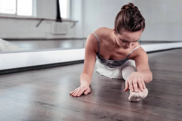 Angenehme attraktive flexible Frau, die ihre Füße berührt — Stockfoto