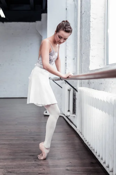 Hermosa bailarina joven de pie cerca de la barra — Foto de Stock