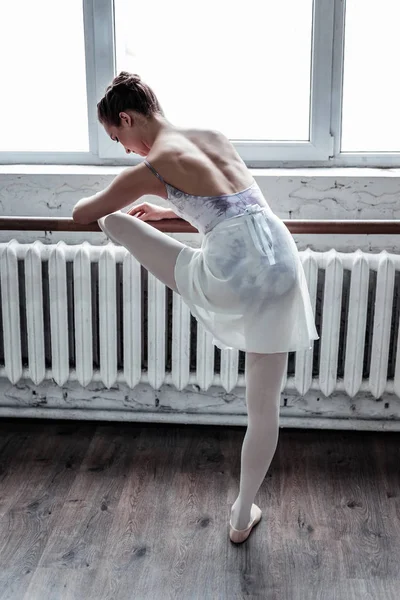 Hermosa bailarina joven de buen aspecto inclinada hacia adelante —  Fotos de Stock